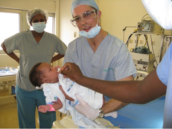 photo - Neil Pollock in Rwanda with a happy patient.