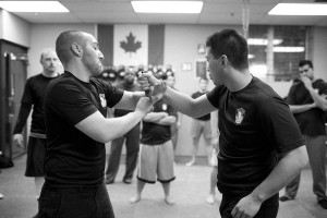 photo - Jonathan Fader, left, and his business partner Borhan Jiang show a class at Urban Tactics Krav Maga how to disarm an attacker who has a knife