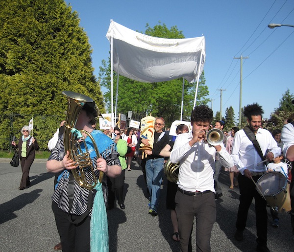 photo - During the parade, led by the Balkan Shmalkan band, the Torah was carried by many different congregation members. In this photo, Henry Grayman is holding it.