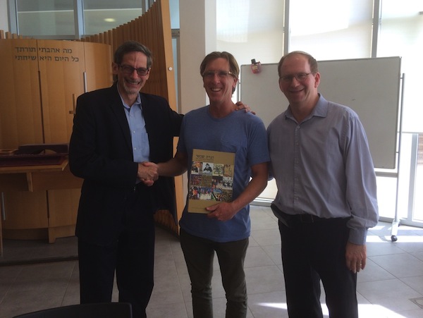 photo - Congregation Beth Israel Rabbi Jonathan Infeld, right, and Howard Mickelson, QC, receive the Schechter Haggadah from the president of the Schechter Institute, Prof. David Golinkin, at the Schechter Institute of Jewish Studies in Jerusalem