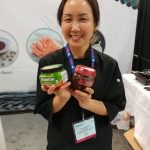 photo - Kimchi seems to be the latest kosher craze. Here, Yeun Sun Shin, manager of South Korea’s Dongbangfood Oil Co. Ltd., shows off some of the company’s products at Kosherfest, which took place Nov. 15-16 in New Jersey