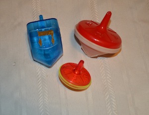 photo - An assortment of plastic dreidels. The two larger tops have removable lids