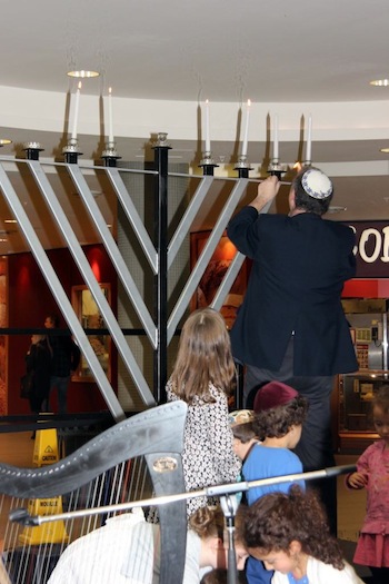 photo - Cantor Yaakov Orzech lights the menorah