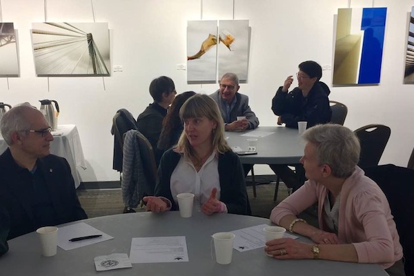 photo - Attendees spoke to one another at their tables, following a list of questions to guide discussion