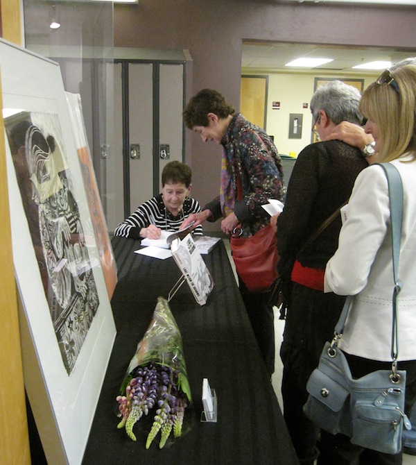 photo - Artist Pnina Granirer signs copies of her book Light Within the Shadows: An Artist’s Memoir at its May 25 launch at Lord Byng High School