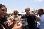 photo - On July 10, at Givat Olga, Indian Prime Minister Narendra Modi, centre-left, and Israeli Prime Minister Binyamin Netanyahu sample water that has just been purified to the World Health Organization standard in the Galmobile.