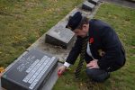 photo - Danny Redden places a poppy at a family grave