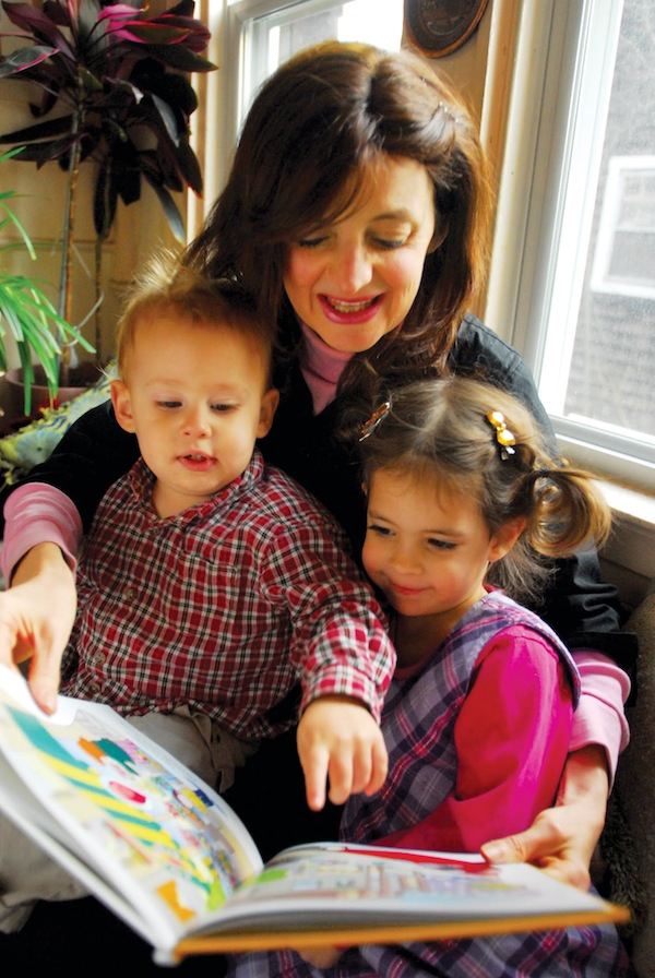 photo - Bracha Goetz reads from one of her recent books to her two grandchildren
