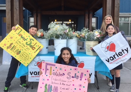 photo - Among other initiatives, RJDS students sold flowers to raise money for Variety. Pictured here are, left to right, Jonathan Estok, Noa Ben-David and Hannah Karasently-Saltoun with teacher Dara Nelson (in the back)
