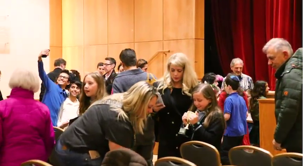 screenshot - This screenshot from the 30th anniversary video of the Public Speaking Contest shows participants’ excitement. Larry Barzelai can be seen at the back of the crowd on the right