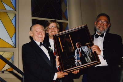 photo - Cantor Murray Nixon, left, and Rabbi Wilfred Solomon, right, hold a framed photo of Nixon taken by Don McGregor, middle, at Beth Israel, circa 1995