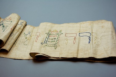 photo - Dr. Michael Hayden, the grandson of Max and Gertrud Hahn, discovered in the 1980s that this Torah binder was in the possession of the City Museum in Göttingen. The piece of cloth was used to swaddle his great-grandfather Raphael Hahn for his brit milah (circumcision ceremony) in 1831. With the help of Göttingen’s mayor, Hayden organized for the Torah binder to be returned to his family