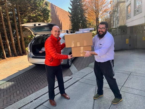 photo - Ezra Shanken, executive director of Jewish Federation of Greater Vancouver, and Rabbi Chalom Loeub, chaplain of Chabad Jewish Student Centre, Vancouver, help with the delivery of seder meals