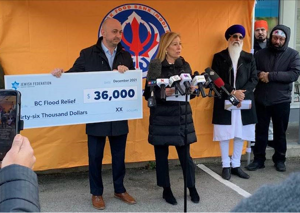 photo - Candace Kwinter, Jewish Federation of Greater Vancouver board chair, and Ezra Shanken, Jewish Federation chief executive officer, present a cheque to the Surrey Sikh Temple and Guru Nanak Food Bank on Dec. 2, as the temple’s head priest and president of the Guru Nanak Food Bank, Narinder Singh, and two volunteers look on