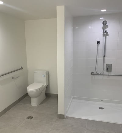 photo - An accessible bathroom features a roll-in shower and open design to accommodate walkers, wheelchairs and other mobility considerations
