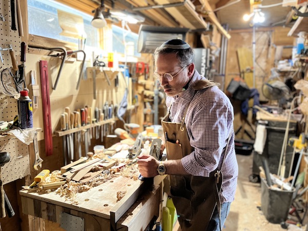 photo - Rabbi Andrew Rosenblatt making one of the challah boards that will be given to honour In a Box volunteers