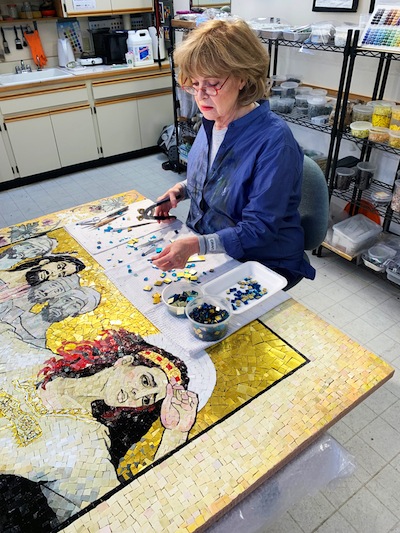 photo - Lilian Broca working on the panel “Mary Magdalene, Defiled and Defamed.” Her exhibit, Mary Magdalene Resurrected, is at Il Museo until Aug. 15