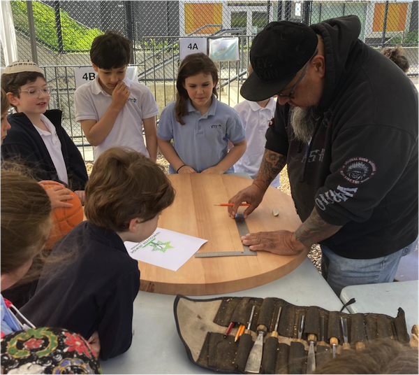 photo - Gerry Sheena shows students his method of carving