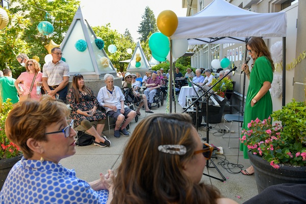 photo - Vanessa Trester, manager of the Weinberg Residence, speaks to those gathered at the 20th anniversary party