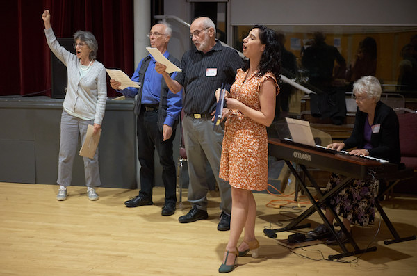photo - The ceremony ended with the singing of “Zog Nit Keynmol.” Left to right are Celia Brauer, Alan LeFevre, Victor Neuman and Kathryn Palmer. At the piano is Cathrine Conings