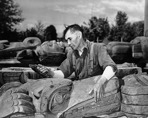 photo - Chief Mungo Martin restoring totem poles, 1949