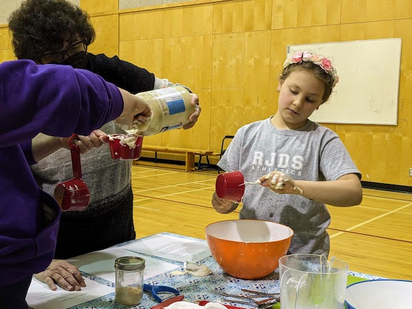 photo - Once a month, students in grades 4 through 7 take an active part in this, helping with the preparation of the meals, including chopping, grating and cooking the plant-based ingredients