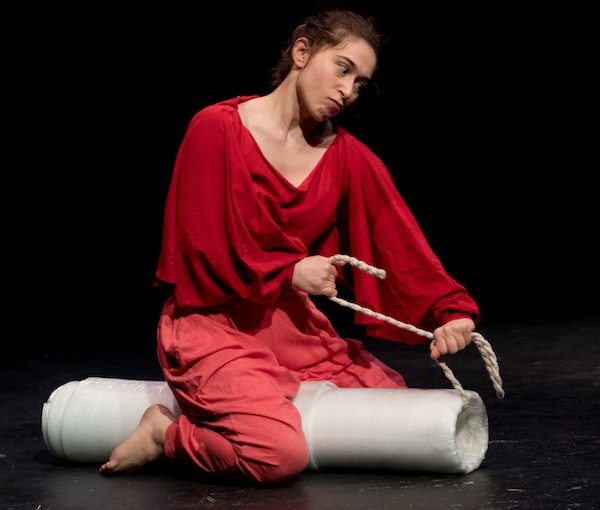 photo - In this scene from their solo physical comedy The Moaning Yoni, Joylyn Secunda is playing the vulva character, Yoni, who is based on the archetype of the Jewish mother (inspired by their own grandmother) – Yoni is strangling the Disembodied Voice of the Patriarchy with a tampon string