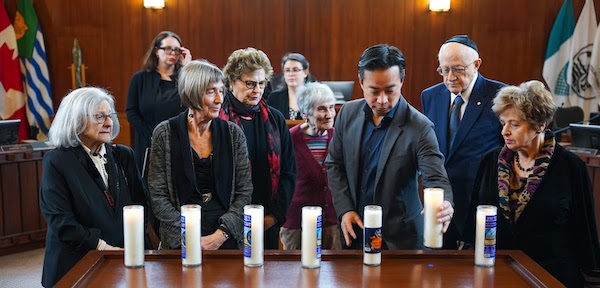 photo - Vancouver Mayor Ken Sim (third from right) lit memorial candles with Holocaust survivors (from left) Rita Akselrod, Amalia Boe-Fishman, Marie Doduck, Claude Romney, Peter Suedfeld and Ella Levitt. Behind are Nina Krieger of the Vancouver Holocaust Education Centre and Cantor Shani Cohen of Temple Sholom