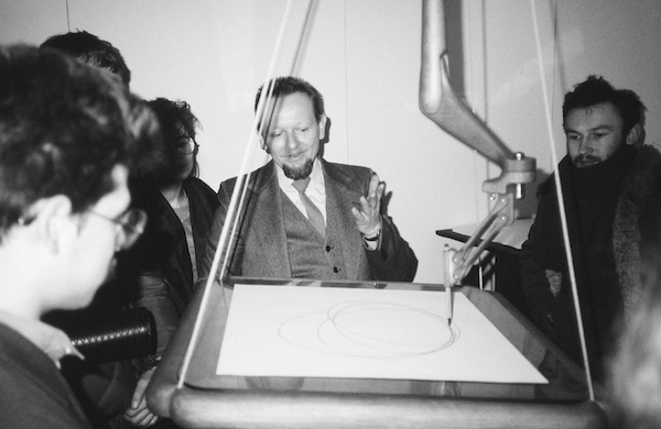 photo - An archival photograph of Andrzej Jan Wroblewski explaining the mechanics of one of his kinetic sculptures, a predecessor of Opus 6