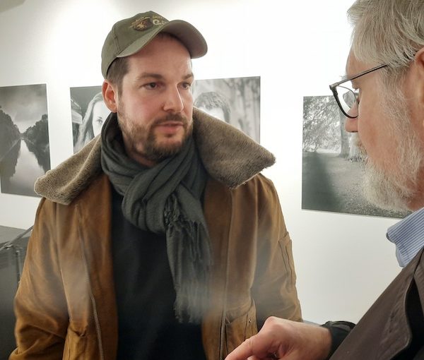 photo - Max Czollek, left, speaks with Prof. Chris Friedrichs, after Czollek launched his new book here Jan. 19