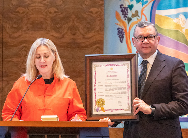 photo - Vancouver Deputy Mayor Sarah Kirby-Yung reads the city’s proclamation of this year’s Wallenberg Day, the framed copy of which is being held by Councilor Mike Klassen