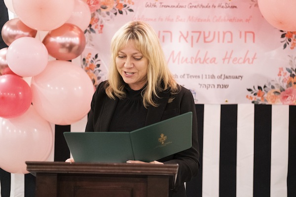 photo - MP Tracy Gray reads the certificate she presented to Chaya Mushka Hecht on the occasion of Mushka’s bat mitzvah