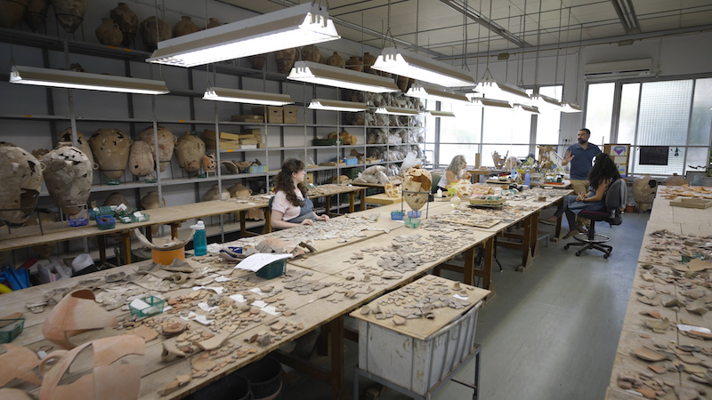 photo - Prof. Erez Ben-Yosef speaking with colleagues in the archeology lab at Tel Aviv University