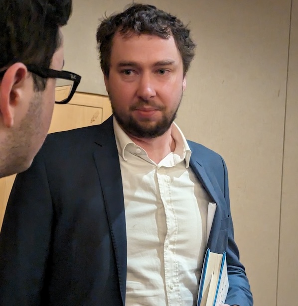 photo - Journalist Tristin Hopper speaks with an audience member after his talk at Congregation Schara Tzedeck Jan. 14
