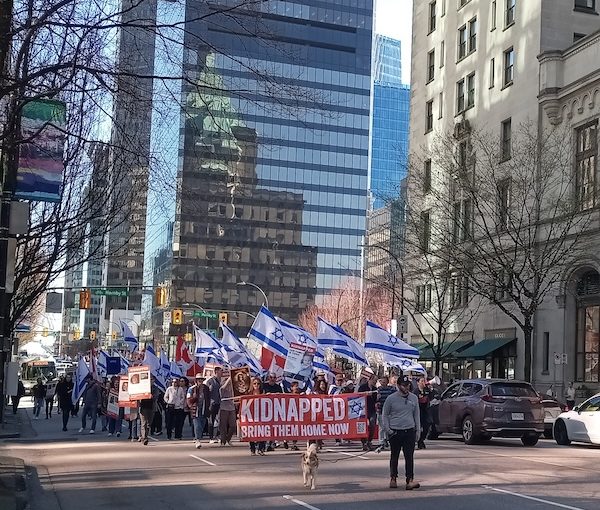 photo - Those who gathered for the weekly rally to call for the release of the Israeli hostages take their message down Georgia Street on Sunday, March 17
