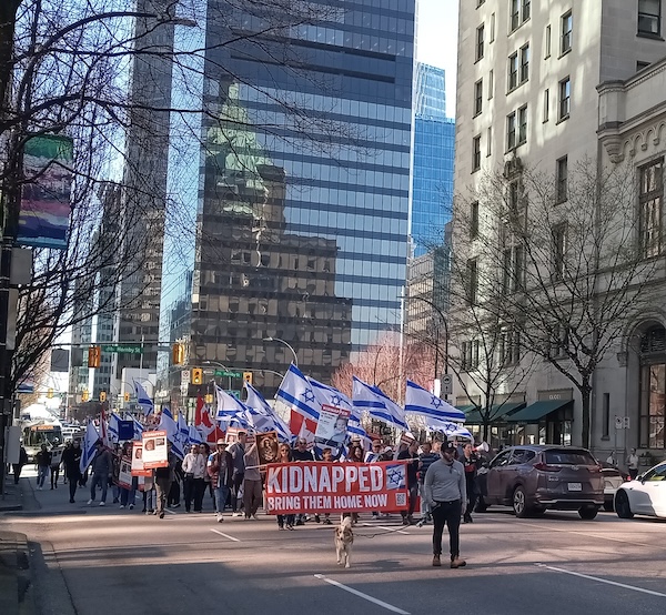 photo - Those who gathered for the weekly rally to call for the release of the Israeli hostages take their message down Georgia Street on Sunday, March 17
