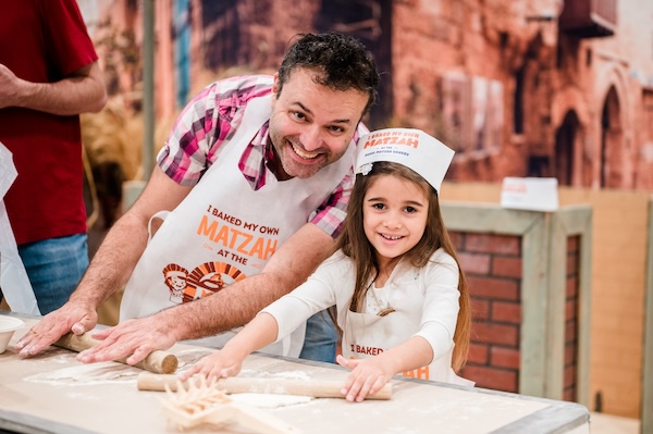 photo - an adult and a young girl making matzah at Lubavitch BC's Model Matzah Bakery in 2024