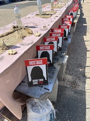 photos - In Hostages Square, there are two tables set up: one for the hostages who have been released (left) and one for those still being held in Gaza (right)