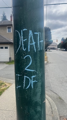 photo - Over the past six to seven months, chalked and adhesive messages have appeared across sidewalks, utility boxes, crosswalk placards and construction signage.
