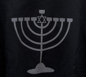 image - The front of the shirt features a menorah that glows in the dark