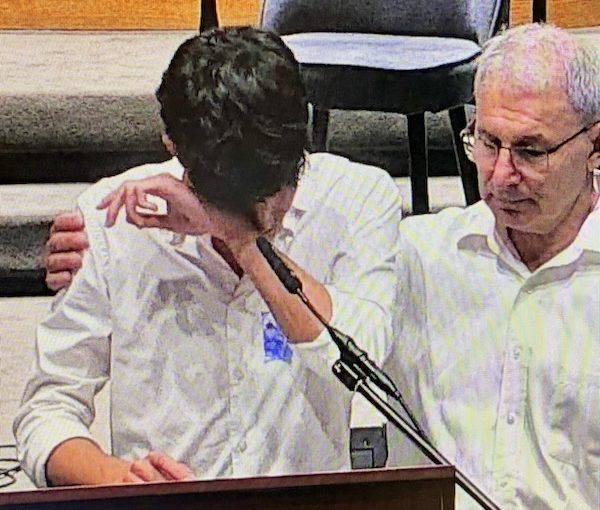 photo - Geoffrey Druker, who leads the community’s annual memorial ceremony, consoles a young speaker on Yom Hazikaron