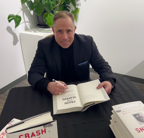 photo - Douglas Century signs copies of his book Crash of the Heavens at the JCC Jewish Book Festival earlier this year