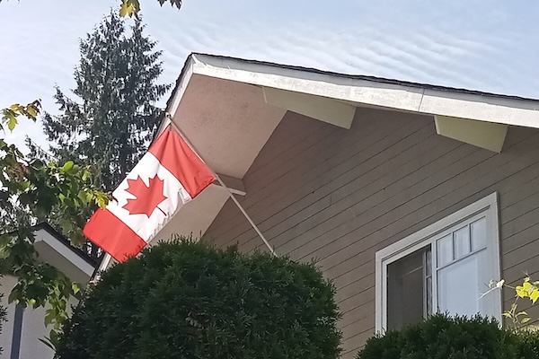 photo - Canadian flag flying from a house