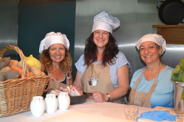 photo - Left to right: writer Lauren Kramer, Ilana Sraier-Phillips and Debbie Zober prepare a traditional cozido stew cooked by geothermal steam in a hole in the ground